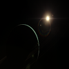 A distant planet viewed from the dark side, a crescent of light is visible, illuminated by the planet's parent star.