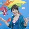 Cheerful woman in front of a colorful map of the world